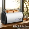 A toaster with bread in it, placed on a wooden table next to a window with a view of trees and sunlight. Produktbild-Vorschau