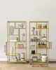 Two gold metal shelving units displaying various home decor and kitchen items, with dimensions indicated on one of the units. Náhled obrázku produktu