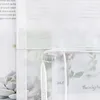 A close-up of a white sheer curtain with a floral pattern and a pull cord mechanism. Produktbild-Vorschau