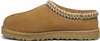 A side view of a brown UGG slipper with decorative trim. Anteprima dell’immagine prodotto