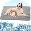 Two dogs, a large golden retriever and a small chihuahua, are lying on a gray cooling mat. Below the mat, there is an illustration of ice cubes with blue arrows indicating cooling. Produktbild-Vorschau