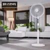 A modern living room with a white stand fan, sofa, and lamp. Voir les images du produit