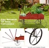 A red wooden wagon filled with plants, shown outdoors on a grassy lawn. The image is split into sections, with one section showing the wagon in use and another highlighting its wheels. Produktbild-Vorschau