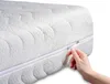 A close-up shot of a white mattress with a zipper being opened by a hand. Náhled obrázku produktu