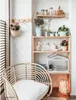 A cozy corner with a chair and shelves filled with plants and decorative items. Produktbild-Vorschau
