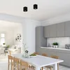 A modern kitchen and dining area with a table and chairs in the foreground, and kitchen cabinets and appliances in the background. An adjacent living room is visible through an opening. Voir les images du produit