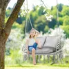 A young girl sits in a hanging chair swing in a garden. Voir les images du produit