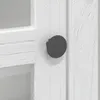Close-up of a white cabinet door with a dark gray knob. Voir les images du produit