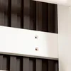 A close-up view of a white support beam with two screw holes, attached to a dark brown wooden slatted wall. Voir les images du produit