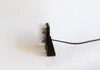 A side view of a black and clear electronic device with a black cable attached, set against a plain white background. Produktbild-Vorschau