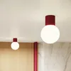 Two modern ceiling lights with burgundy bases and white globe shades are mounted on a white ceiling. Produktbild-Vorschau