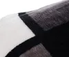 A close-up view of a soft blanket with a plaid pattern. Produktbild-Vorschau