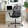 A black ergonomic office chair is shown in a home office setting, with a desk, laptop, and plant visible. Produktbild-Vorschau