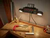 A workbench with tools and a power strip with lights and USB ports mounted on the wall. Produktbild-Vorschau