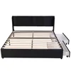 A black upholstered bed frame with a slatted wooden base and two open drawers on the right side, shown against a white background. Produktbild-Vorschau