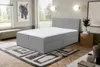 A bedroom scene with a bed, rug, and artwork. Voir les images du produit