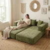 A woman is reading a book while sitting on a modular green sofa in a living room. Voir les images du produit