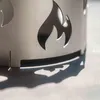 A close-up shot of a metal wok attachment with flame cutouts, casting a shadow on a light-colored surface. Produktbild-Vorschau