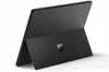 A black Microsoft Surface tablet is shown from a rear-facing diagonal angle, with its kickstand extended. Produktbild-Vorschau