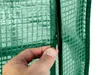 A hand is shown zipping up a green greenhouse. Anteprima dell’immagine prodotto