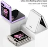Three different colored phone cases for a foldable phone are displayed on white pedestals. Náhled obrázku produktu