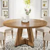 A round wooden dining table with chairs around it in a well-lit room. Anteprima dell’immagine prodotto
