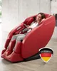 A woman is relaxing in a red massage chair, holding a remote control. A German flag emblem is visible on the lower right side of the chair.