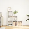 A white, multi-tiered bookshelf filled with decorative items and books, placed against a plain white wall. Voir les images du produit