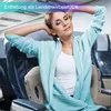 A woman is relaxing on an airplane seat with an inflatable lumbar support pillow. Produktbild-Vorschau