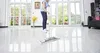 A person is mopping a shiny floor in a bright room with large windows. Voir les images du produit