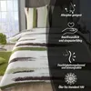A bed with a duvet cover and pillowcase with a brushstroke design, set against a winter window view and a dark background with feature icons and text. Produktbild-Vorschau