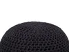 A close-up view of a dark-colored knitted pouf. Produktbild-Vorschau