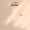 A tall, clear glass jar with a bamboo lid, with dimensions indicated by dashed lines and text. Produktbild-Vorschau