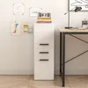 A white filing cabinet with three drawers is shown next to a desk. Náhled obrázku produktu