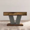 A square coffee table with a V-shaped base, made of wood with a rustic finish, placed on a rug. Anteprima dell’immagine prodotto