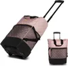Two views of a pink quilted rolling shopping bag with black accents and wheels. Produktbild-Vorschau