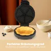A waffle maker is shown open with a freshly made waffle inside, next to a bowl of whipped cream and blueberries. There is also a bowl of batter with a whisk. Náhľad obrázku produktu