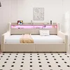 A beige upholstered daybed with integrated shelving and LED lighting, set against a white wall and a patterned rug. Náhľad obrázku produktu