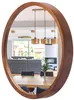 A round wooden mirror reflecting a dining room and living room. Anteprima dell’immagine prodotto