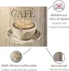 A close-up of a coffee cup and saucer with the word 'CAFÉ' above it, set against a wooden background. Informational callouts are present on the right and bottom of the image. Produktbild-Vorschau
