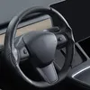 A close-up view of a car's steering wheel with a carbon fiber cover. Náhled obrázku produktu
