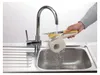 A person is rinsing a cheese grater under a kitchen faucet. Produktbild-Vorschau