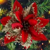 A close-up of a red and gold artificial poinsettia flower ornament on a Christmas tree. Produktbild-Vorschau