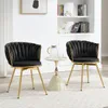 Two black velvet chairs with gold legs are placed on a rug in a room with a bookshelf in the background. Produktbild-Vorschau