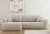 A beige sectional sofa with a ribbed texture is shown in a minimalist living room setting.