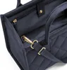 A close-up view of the interior and strap attachment of a navy blue quilted bag. Voir les images du produit