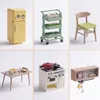 A collage of miniature kitchen items, including a refrigerator, a rolling cart, a chair, a table with food, a stove, and a cabinet. Podgląd zdjęcia produktu