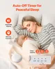 A woman sleeping next to a baby, with a white noise machine on the bed. Produktbild-Vorschau
