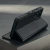 A black leather phone case with a stand function is displayed on a gray surface. Produktbild-Vorschau