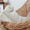 A close-up of a woven basket with a textured blanket inside. Produktbild-Vorschau